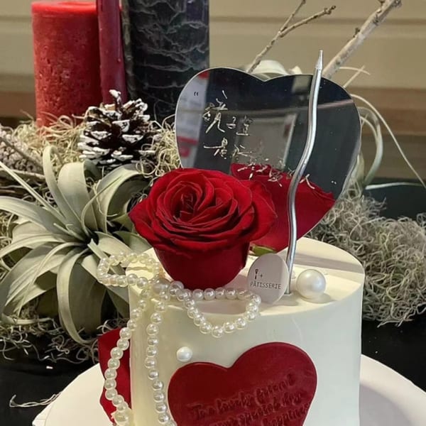 Studio Multisweet dessert: white cake with red rose, pearls, heart, and mirrored topper.