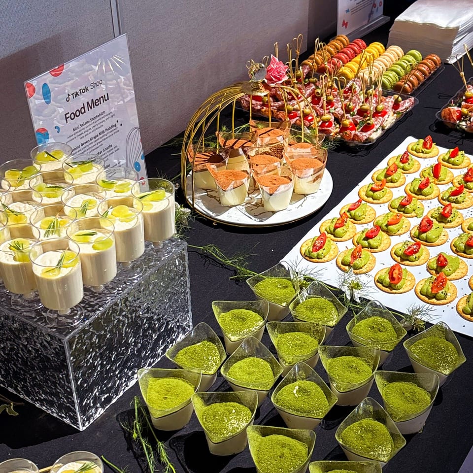 A dessert buffet with various small treats, including tiramisu, green grape milk pudding, and matcha desserts.