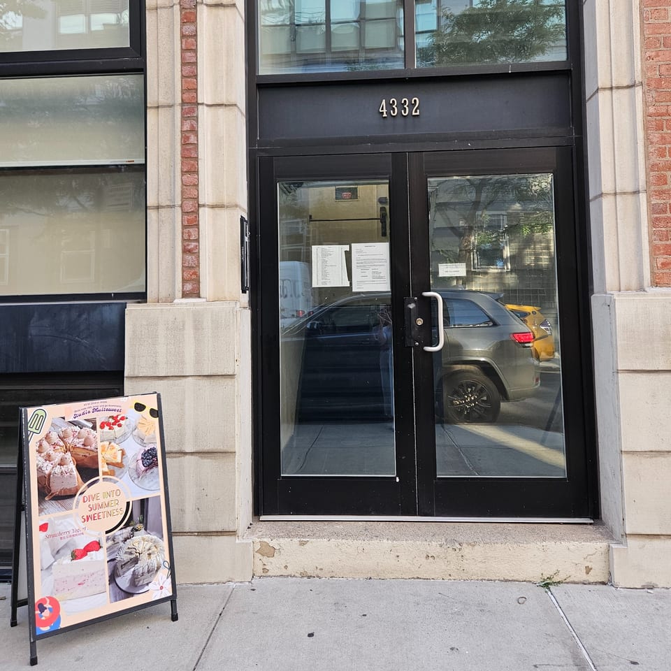 Studio Multisweet storefront with a dessert menu A-frame sign on the sidewalk.