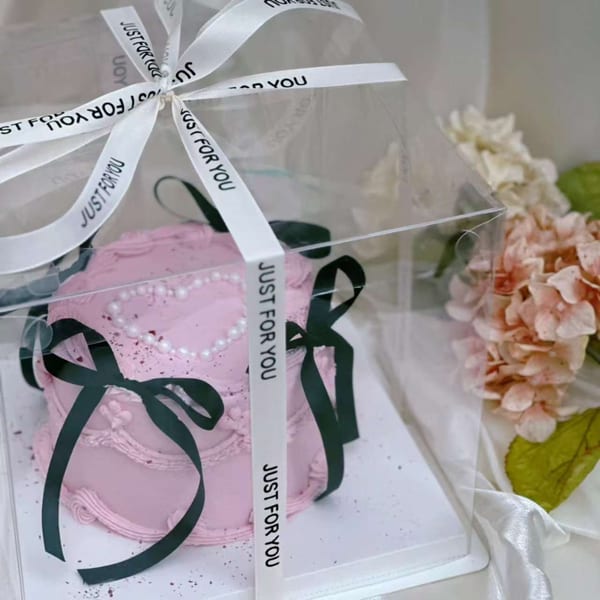 Pink Studio Multisweet cake with pearl heart design, black ribbons, and "Just For You" white ribbon in a clear box.